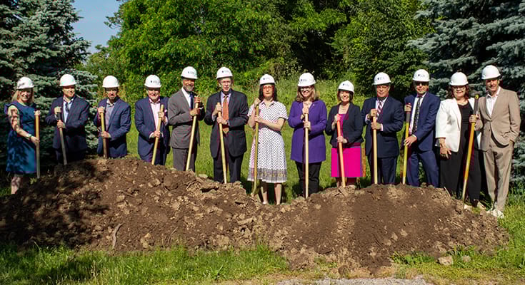 Groundbreaking ceremony with staff holding shovels