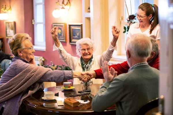 Residents and staff celebrating at a table