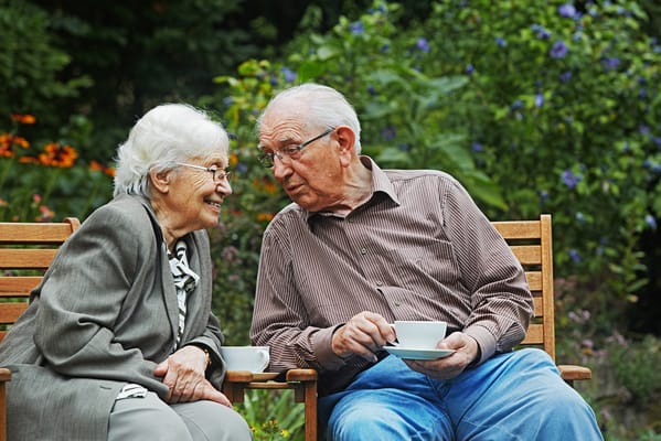 Elderly couple enjoying tea in a garden