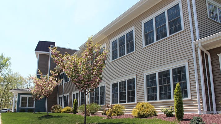 Exterior view of a senior living facility with flowering trees