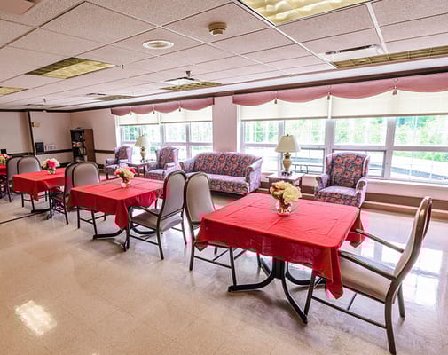 Bright common area with red tablecloths and floral centerpieces