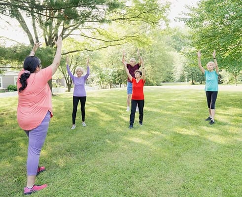 Seniors participating in a stretching exercise outdoors