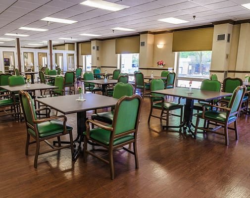 Bright dining room with green chairs and tables