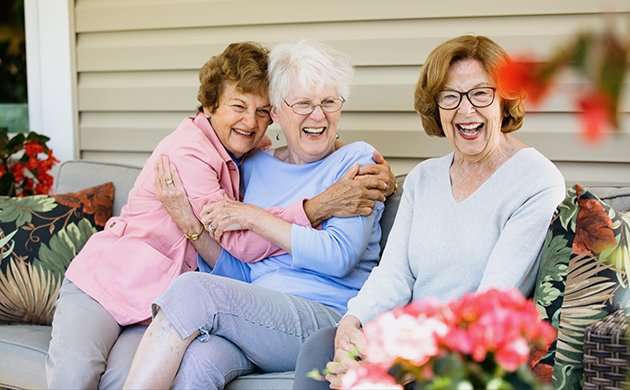 Three smiling women enjoying each other's company outdoors