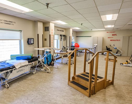 Physical therapy room with equipment and motivation quotes
