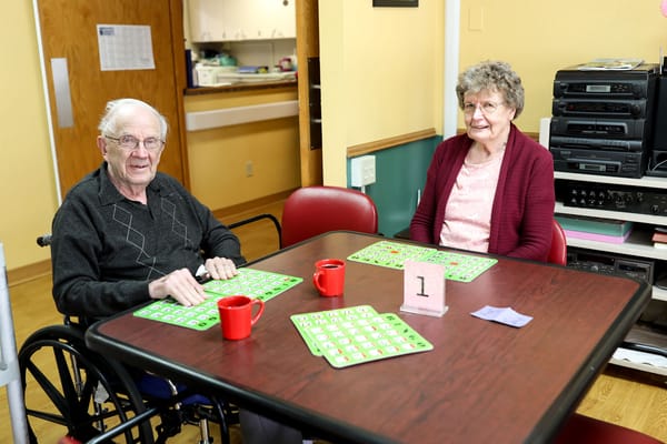 Two residents engaging in a bingo game in an activity room