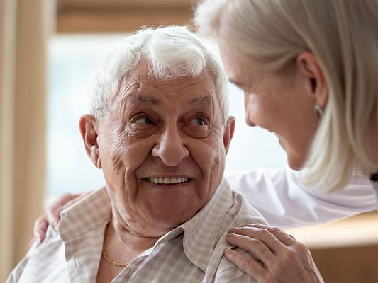 Resident smiling with staff member in a caring moment