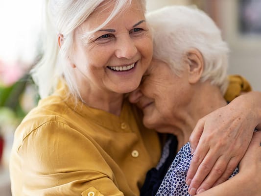 Caregiver embracing a resident in a heartwarming moment