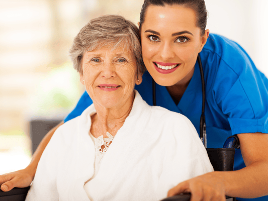 A caregiver smiling with a resident in a warm setting