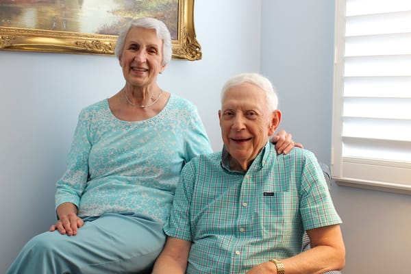 Two residents smiling together in a bright room