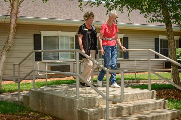 Staff assisting a resident with mobility outdoors