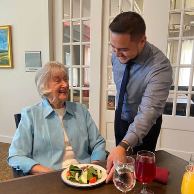 Caregiver serving a resident in the dining room