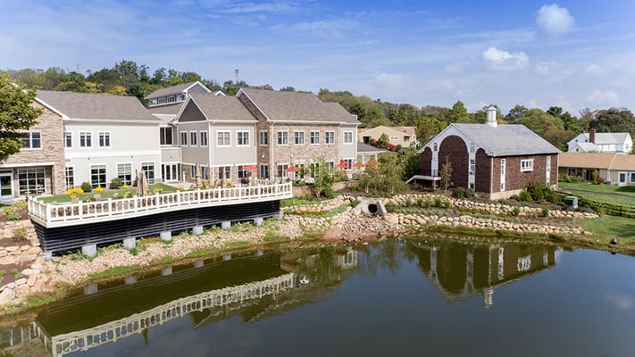 Aerial view of a senior living facility beside a pond