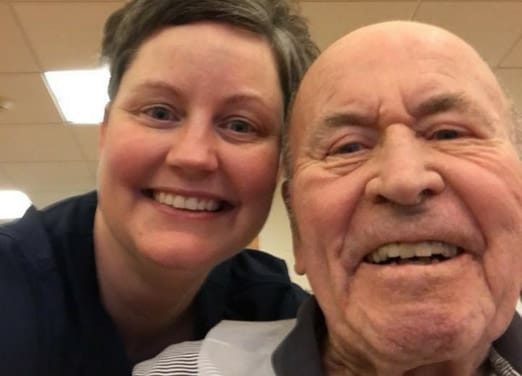 A caregiver and a resident smiling together