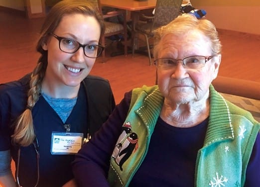 Staff member posing with a resident in a cozy setting