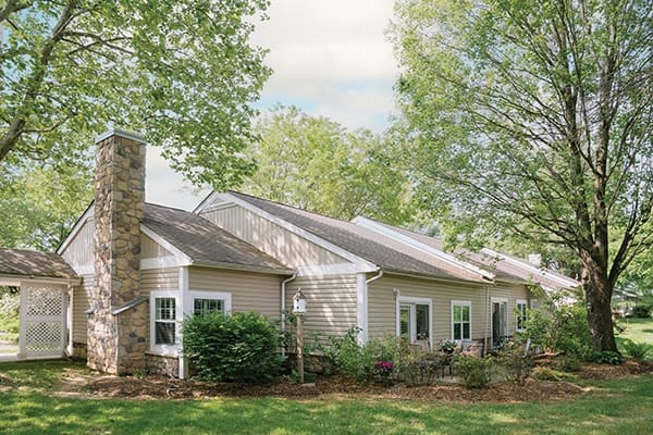 Exterior view of a senior living facility surrounded by trees