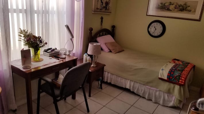 A cozy resident room with a bed and desk