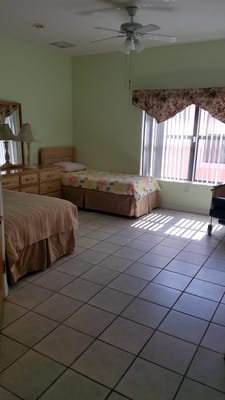 Bright interior view of a resident room with beds and furniture