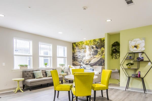 Bright common area with seating and nature mural