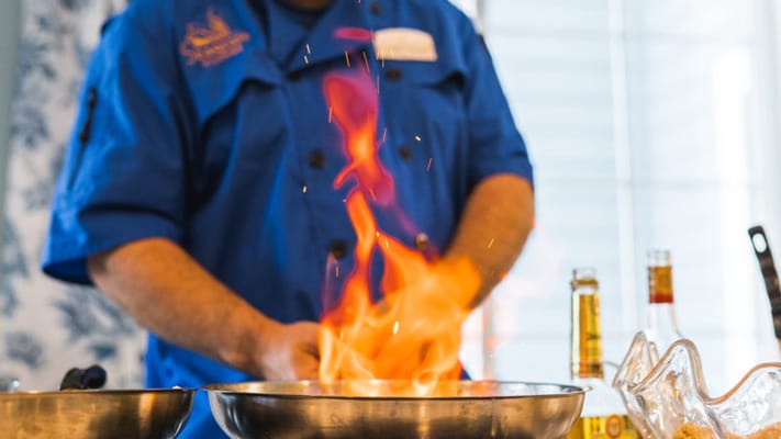 Chef preparing a fiery dish in the kitchen