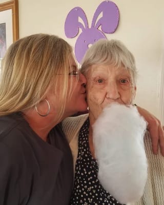 Staff member sharing cotton candy with a resident
