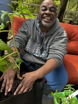 Resident gardening outdoors with a smile
