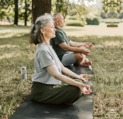 Seniors practicing yoga outdoors in a peaceful setting