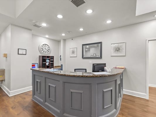 Reception area with a gray desk and wall clock