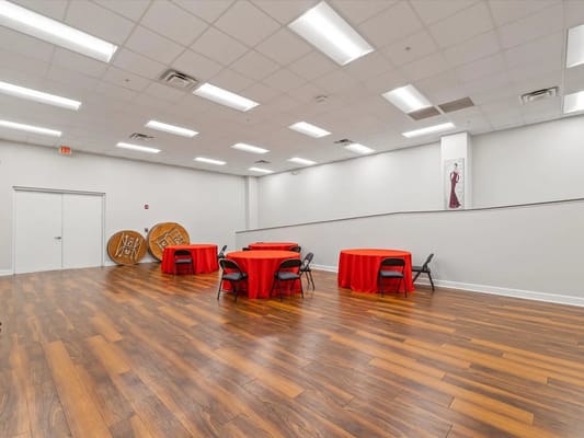 Empty event space with red tables and chairs