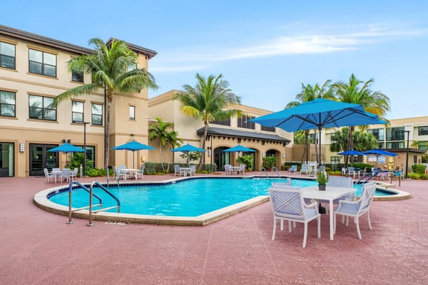 Swimming pool area with blue umbrellas and chairs