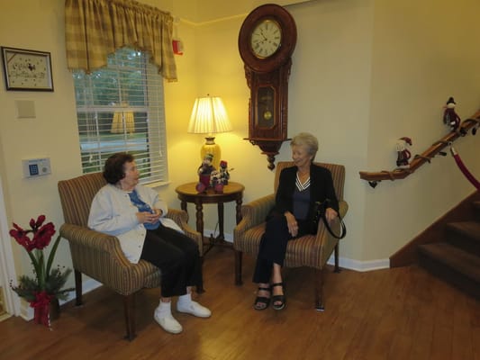 Two residents chatting in a cozy seating area