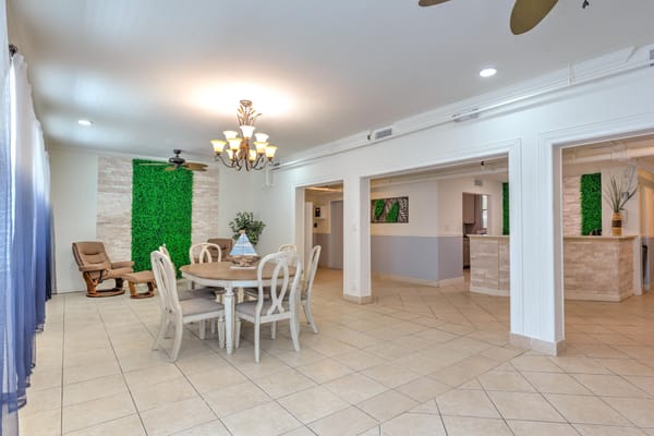 Bright common area with dining table and green decor