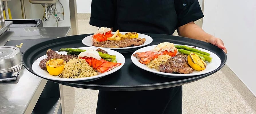 Staff serving gourmet meals on a tray