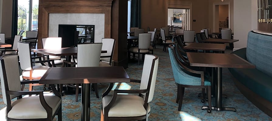 Dining area with tables and chairs in a senior living facility
