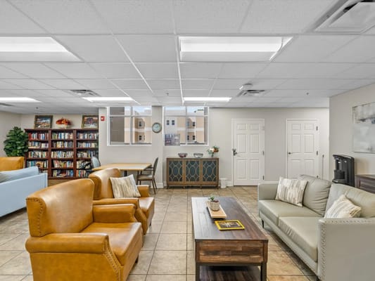 Common area with seating and bookshelf in a senior living facility