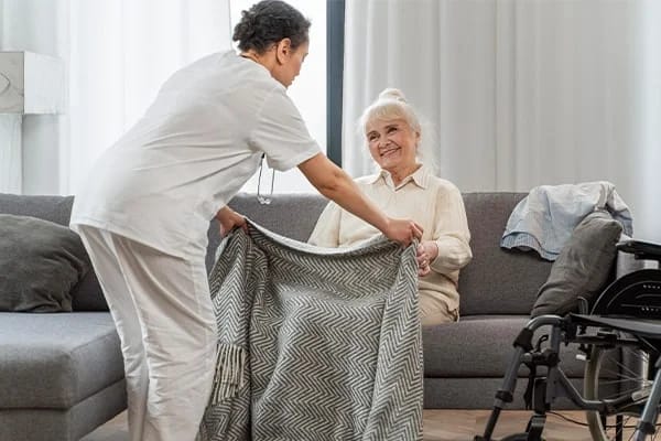 A caregiver assisting a smiling senior resident indoors