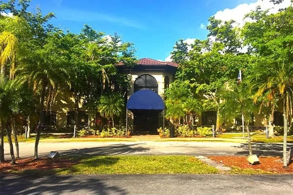Front view of the Westchester of Sunrise building surrounded by greenery