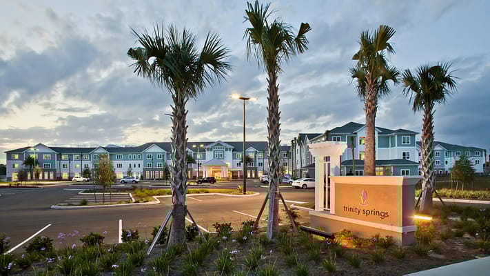 Exterior view of Trinity Springs facility with palm trees