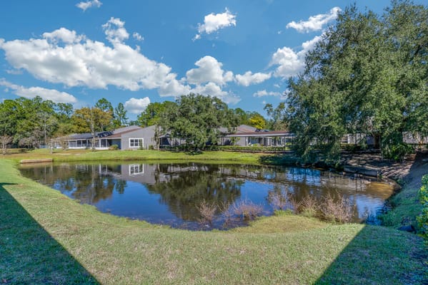 Outdoor view of facility grounds by a pond