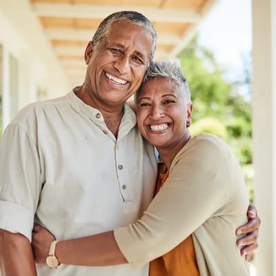 A smiling couple embracing outdoors