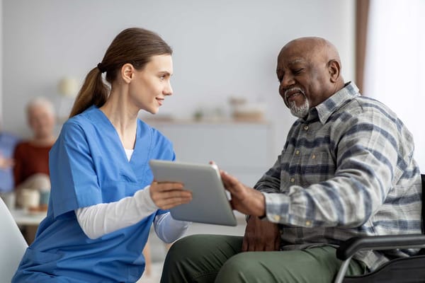 Nurse assisting a resident with a tablet