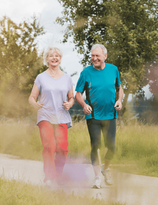 Seniors jogging together on a sunny path