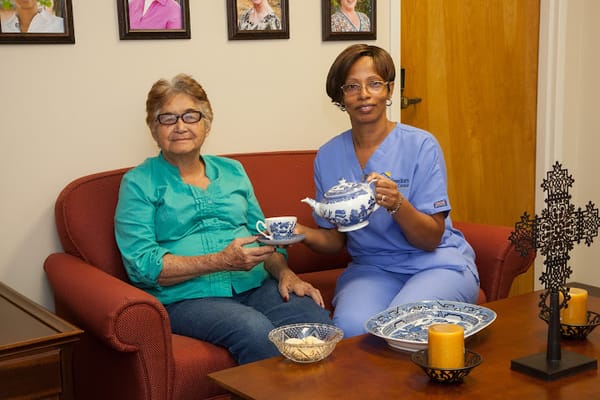 Care staff serving tea to a resident in a cozy living space