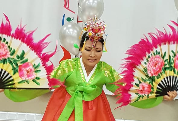 Resident performing traditional dance with colorful fans