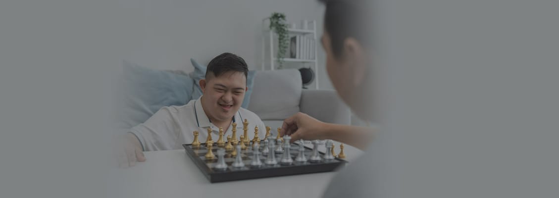 Residents enjoying a game of chess in a bright room
