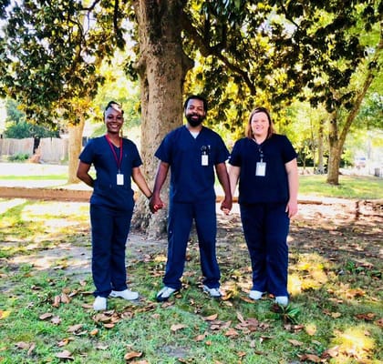 Three staff members standing together outdoors