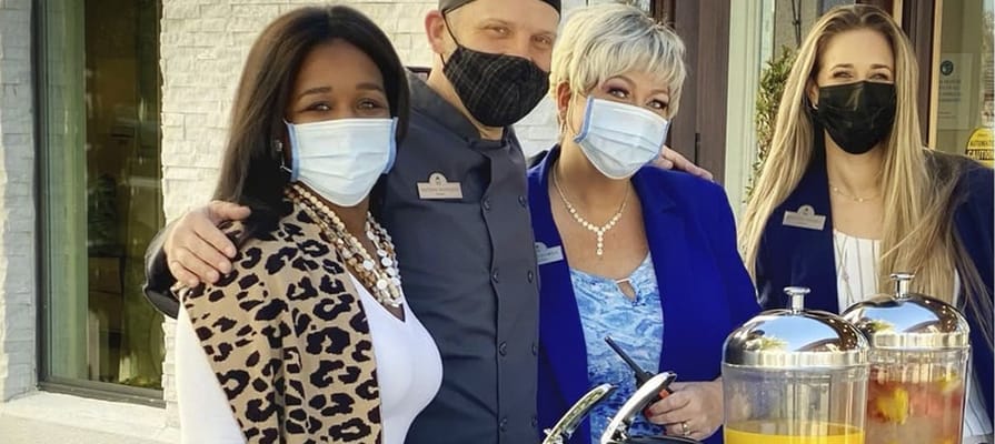 Staff posing together with refreshments in an outdoor area