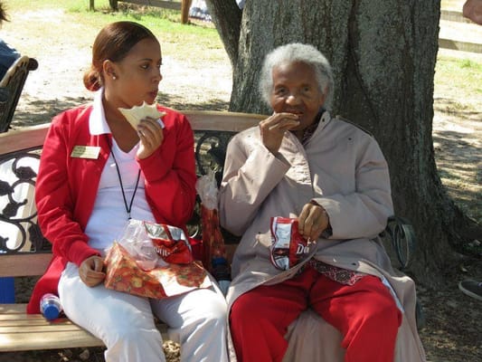 Resident and staff enjoying snacks in an outdoor space