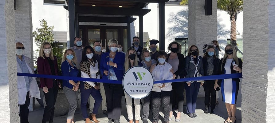 Ribbon-cutting ceremony with staff and residents at the entrance