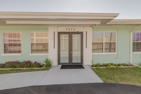 Exterior view of a facility entrance with landscaping